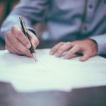 a person writing on a piece of paper