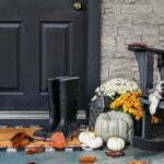 a black chair and a table with a vase of flowers and a black chair and a white door
