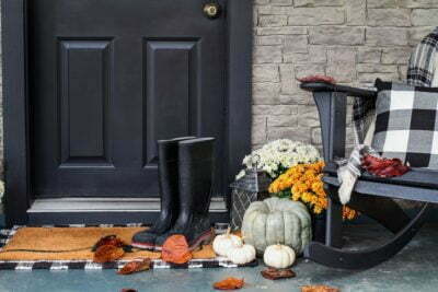 a black chair and a table with a vase of flowers and a black chair and a white door