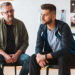 a couple of men sitting in chairs