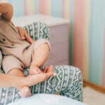 Young mother is breastfeeding her baby. In Vitro Fertilization IVF . Family of asians