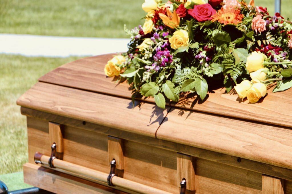 Lovely floral arrangement on wood casket.