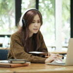 a woman wearing headphones and sitting at a desk