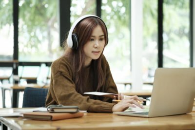 a woman wearing headphones and sitting at a desk